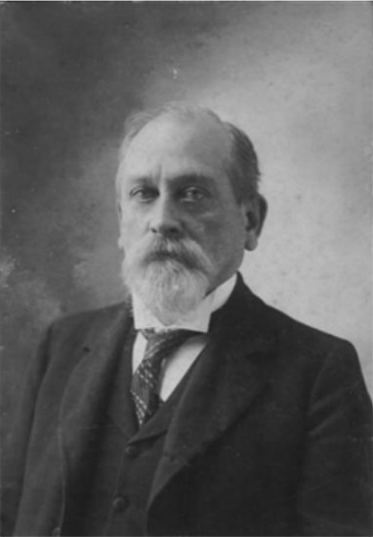 Alfred Moore Waddell is in three piece  suit and tie with a mustache and beard in a goatee style.