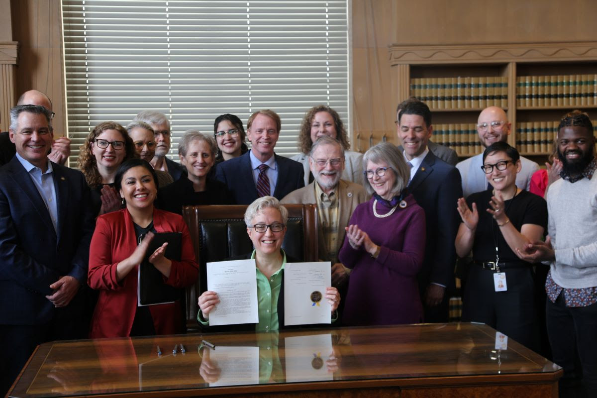 Tina holding up newly signed law