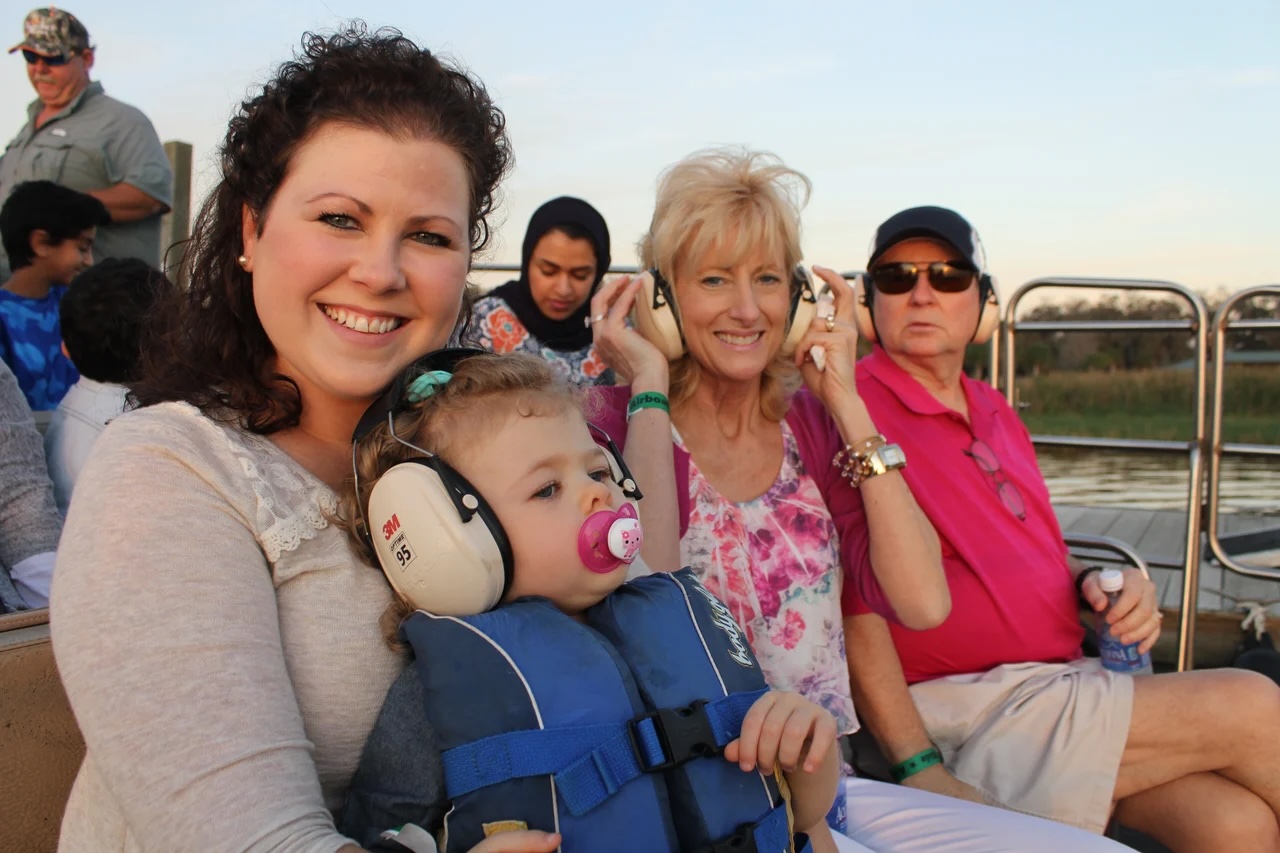 A child and parent enjoy an evening airboat tour at Wild Florida