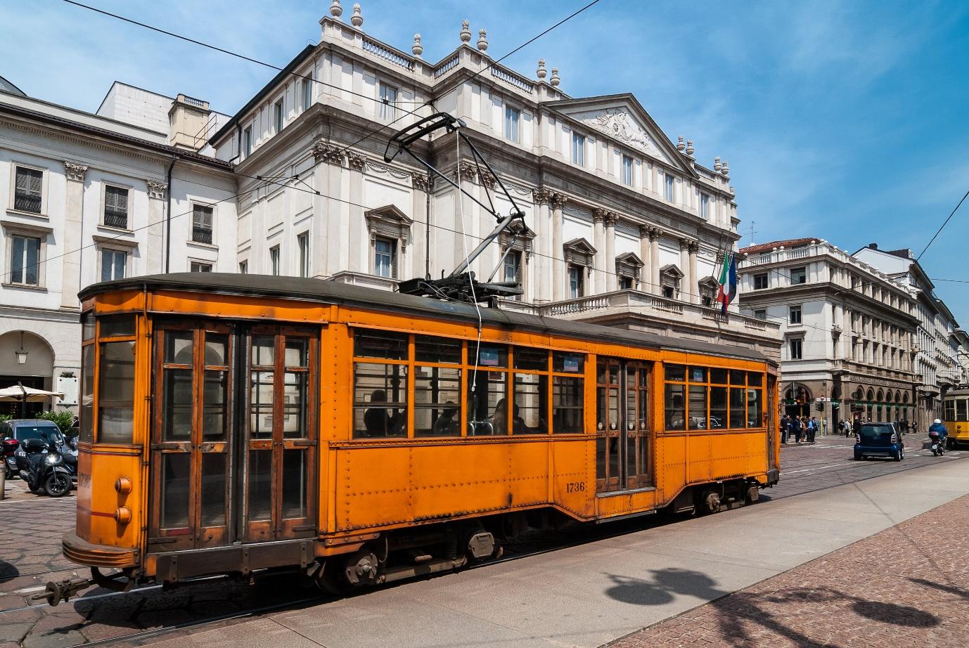 A trolley car in front of a building

Description automatically generated