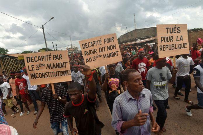 Demonstrators hold signs reading "Beheaded for saying no to unconstitutional third term" and "Killed for the republic" during a march to denounce the death of protesters who have been killed in poll-linked violence, in central eastern Daoukro, on November 21.