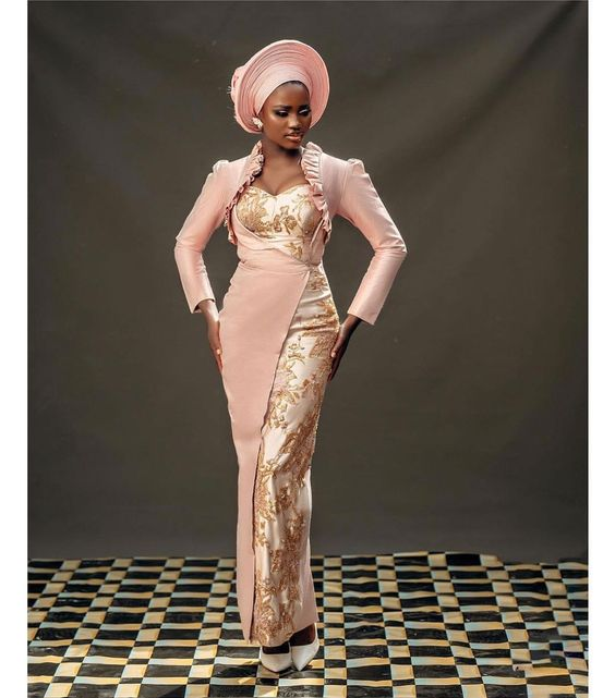Picture of a lady in pink looking god with her Aso ebi fashion