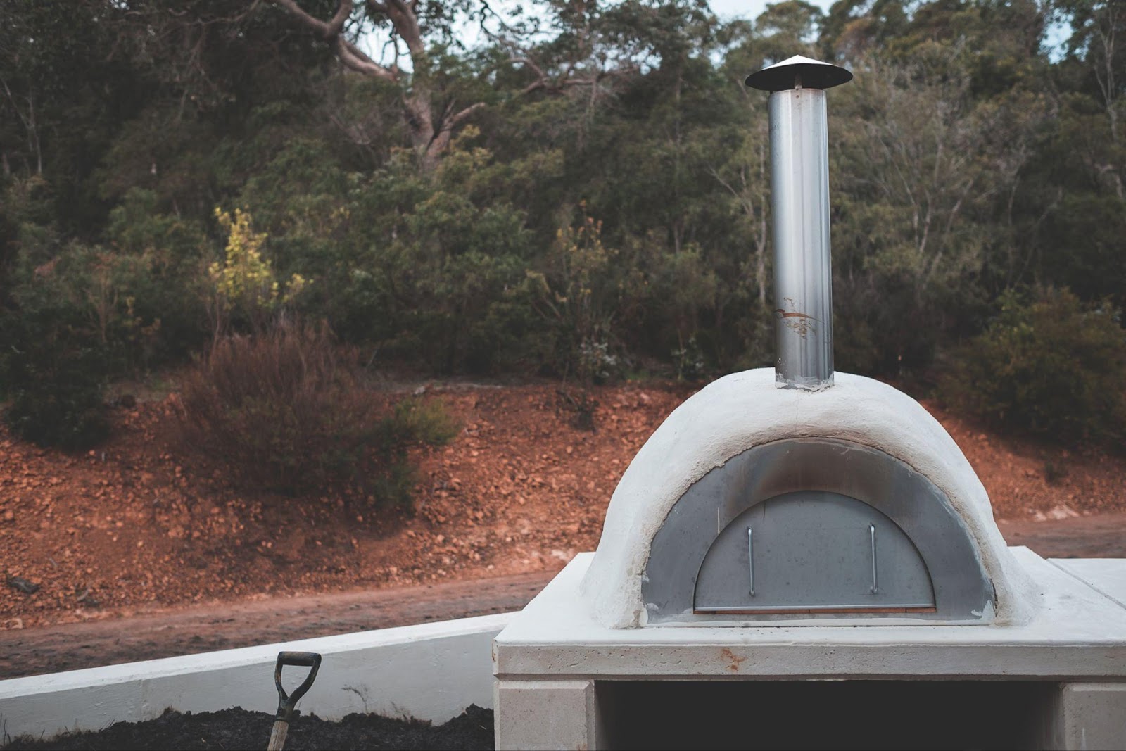 A outdoor oven with a chimney

Description automatically generated