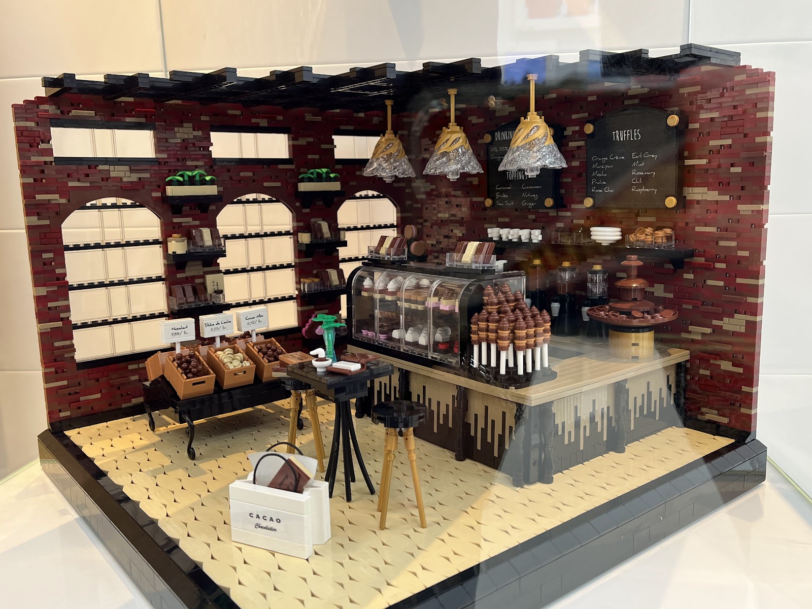 A photo of the LEGO creation Chocolate Shop by Kelly Bartlett, on display in the Masterpiece Gallery in the LEGO House