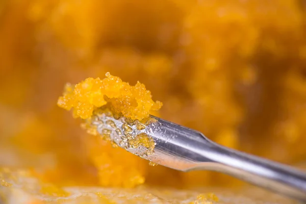 Silver tong with live resin from marijuana
