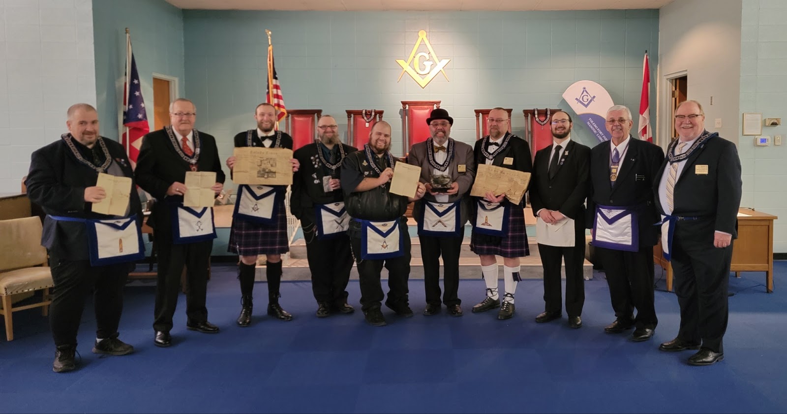 Image of Masons standing in masonic garb holding up old newspapers from Toledo, Ohio.