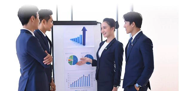 A group of people standing in front of a white board

Description automatically generated