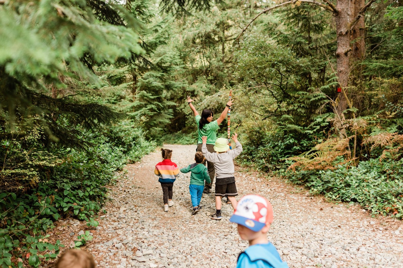 a Wild and Immersive program leader leading 4 small children along a hike