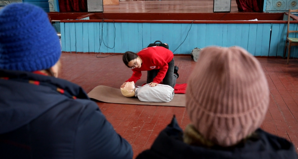 Інструкторка з Товариства Червоного Хреста України показує на манекені, як перевірити, що трапилося з пораненою людиною