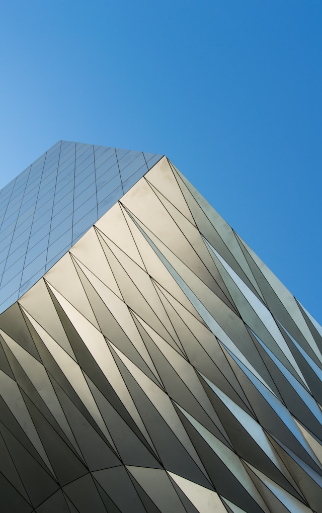 A building with a metal facade with a blue sky background designed using BIM and generative design