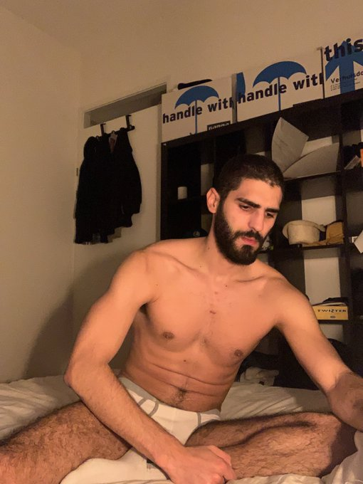 karim yoav sitting on the bed wearing white briefs