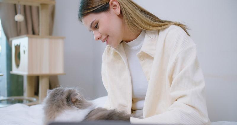 una joven hablando y acariciando a su gato