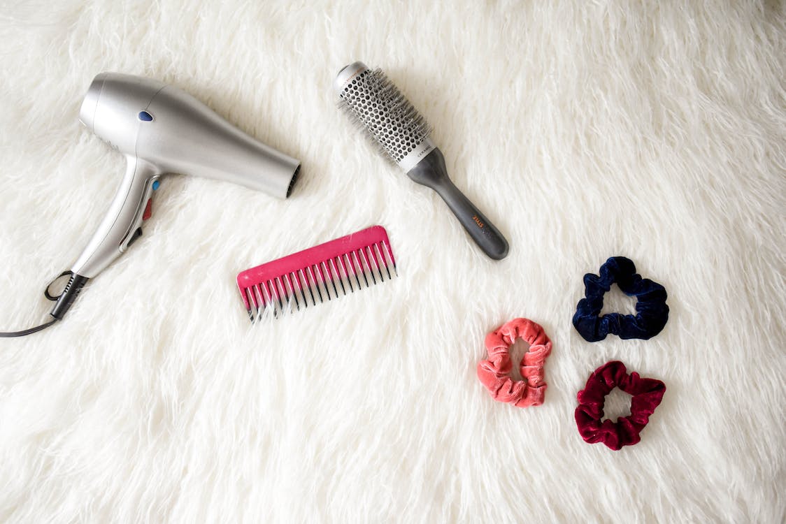 Free Grey Hair Blower Near Pink Hair Combs and Scrunchies Stock Photo