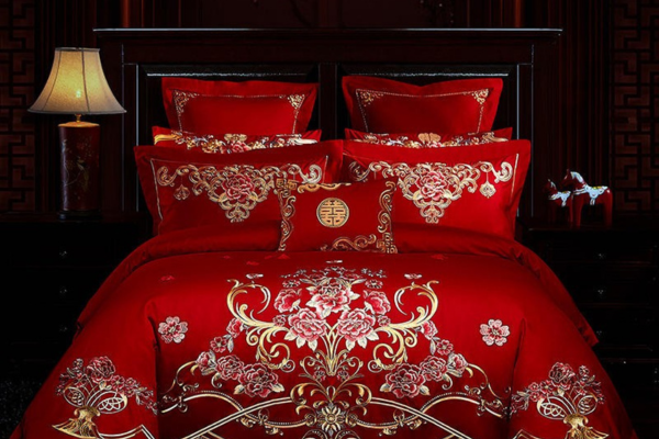 Bed with red sill bed sheet and pillow covers