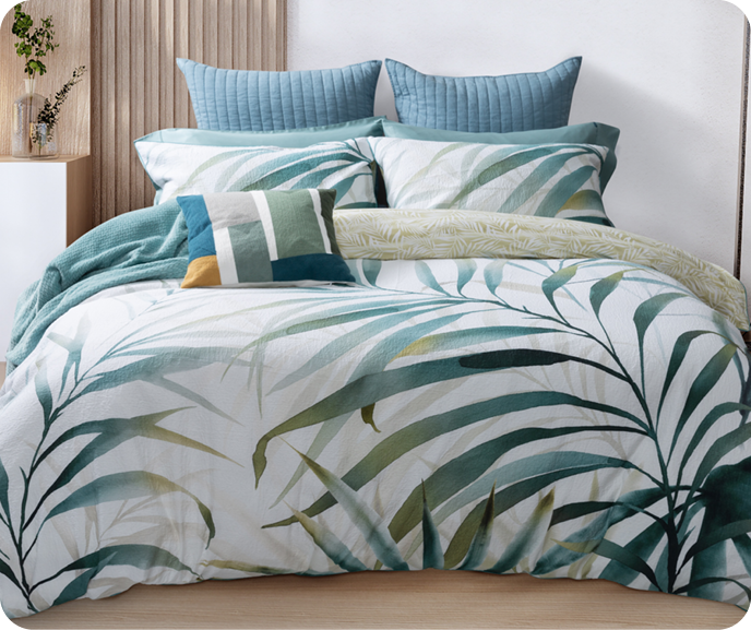 Our Botanical Bonita Duvet Cover shown on a bed with coordinating blue accessories and the Bonita Square Cushion Cover.