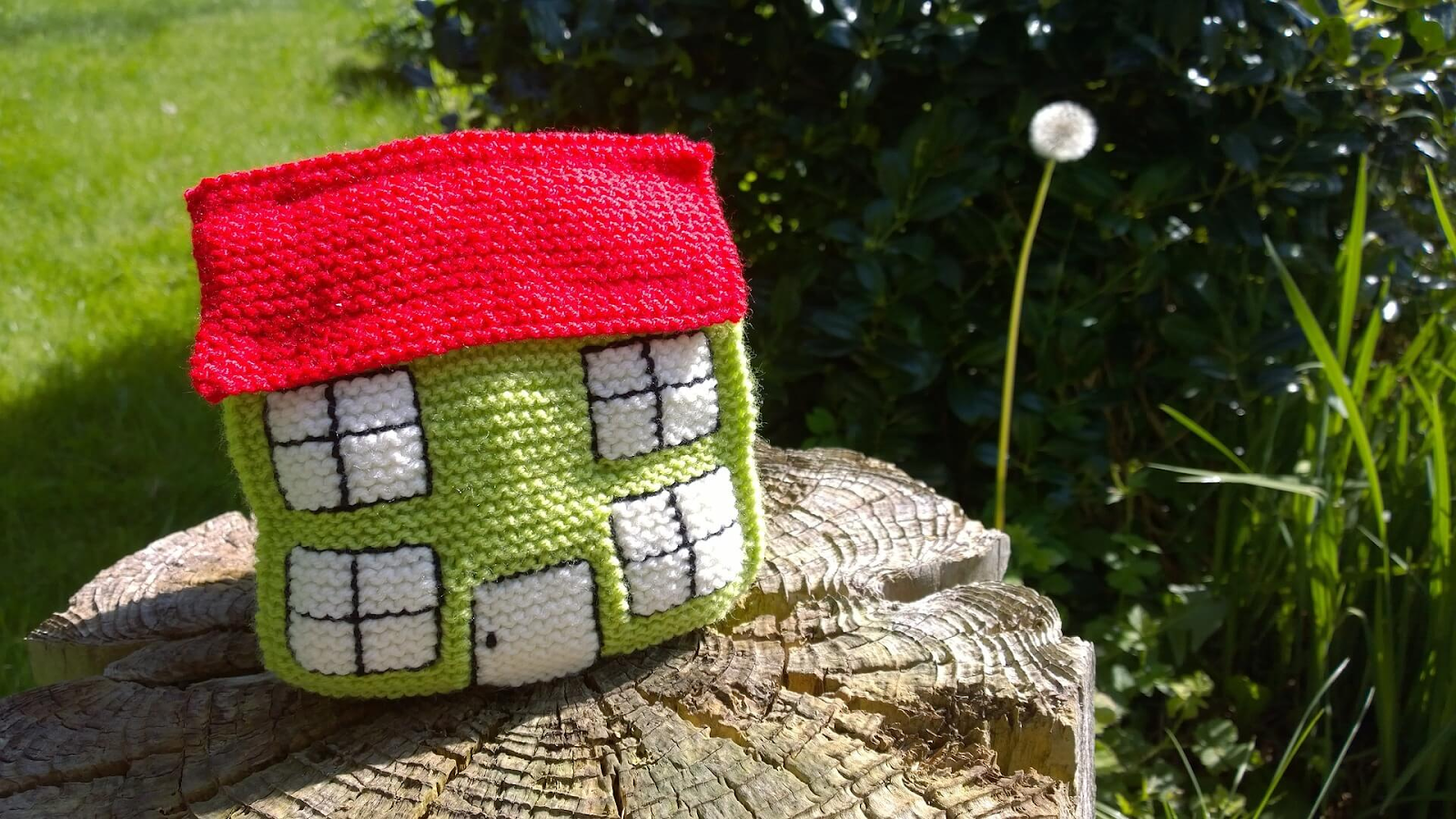 a knitted house model on a wood