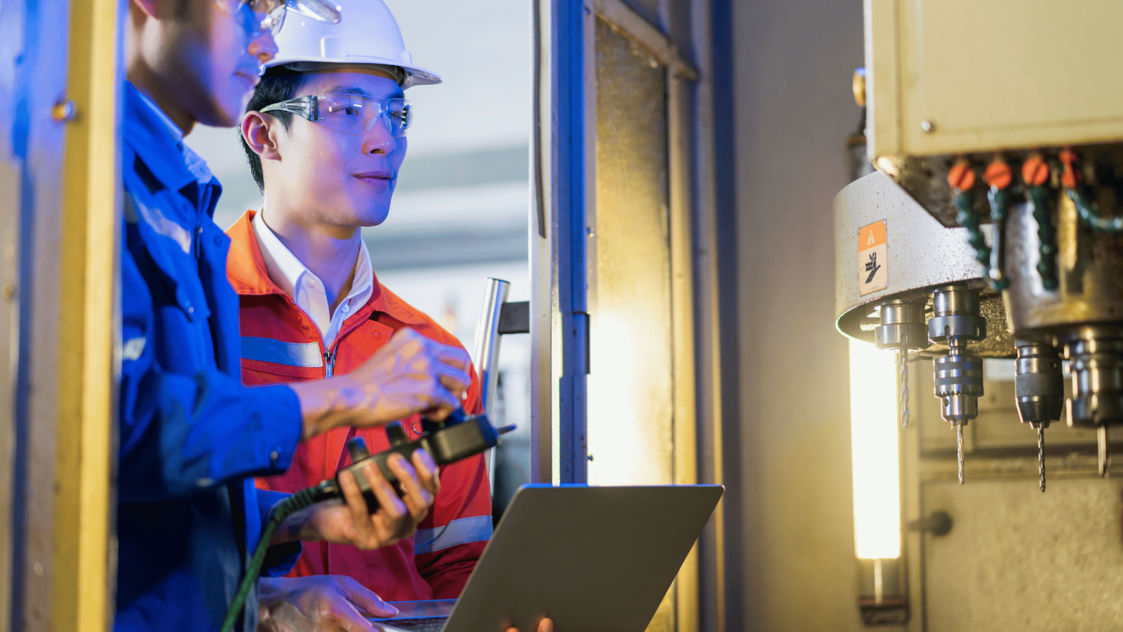 Two engineers in safety gear conducting quality control measures in investment casting with advanced machinery.
