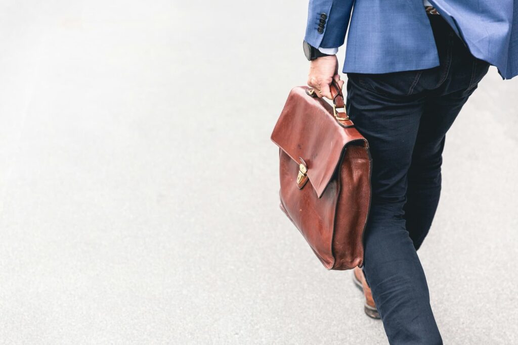 A young professional carrying a briefcase while walking down the street