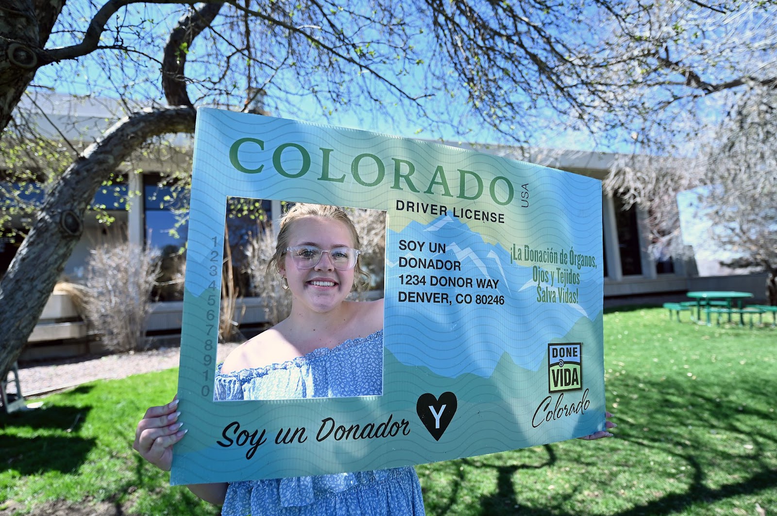 Sixteen-year-old Lella Young poses for a photo with a large driver license Thursday, April 4, 2024, after a flag-raising ceremony at DMV headquarters in Lakewood.