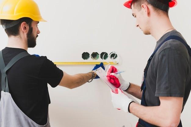 Two handymen making measures