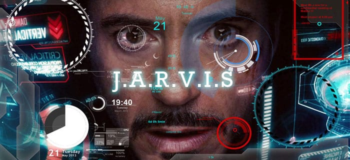 Man behind a clear computer with J.A.R.V.I.S. across the screen