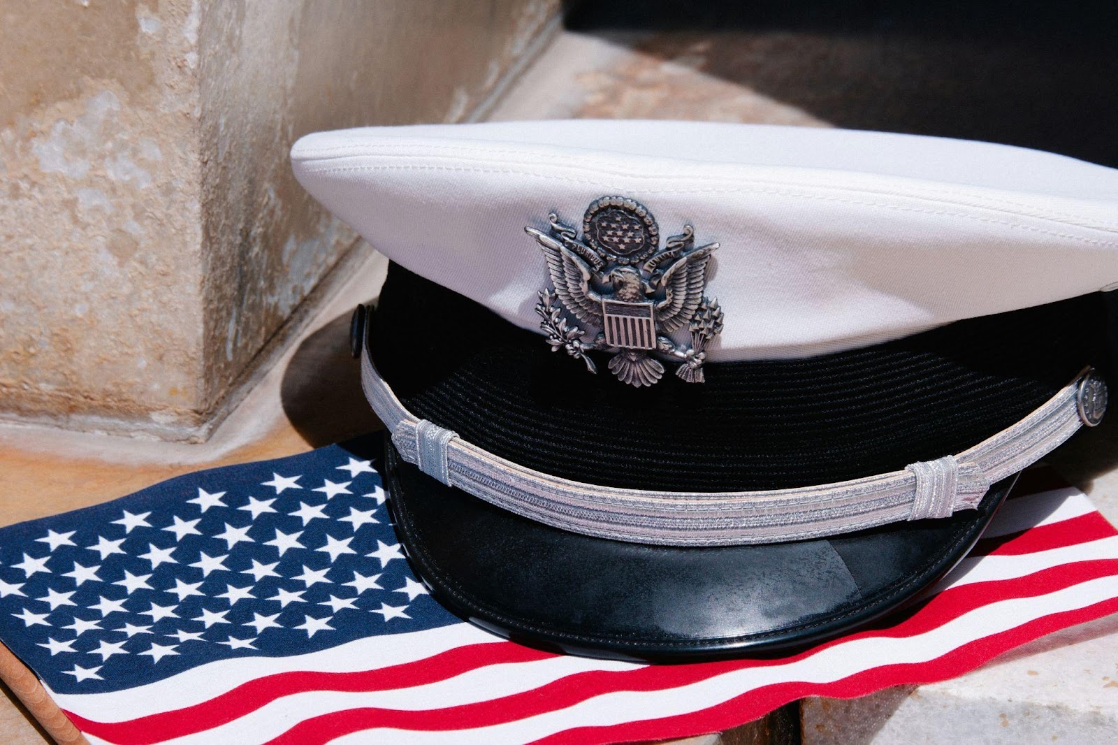 a military hat on top of an American flag