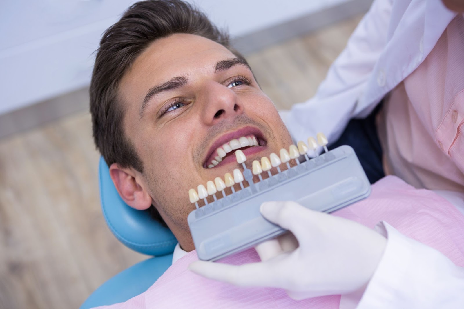 Man looking at dentist getting teeth samples for dental crowns