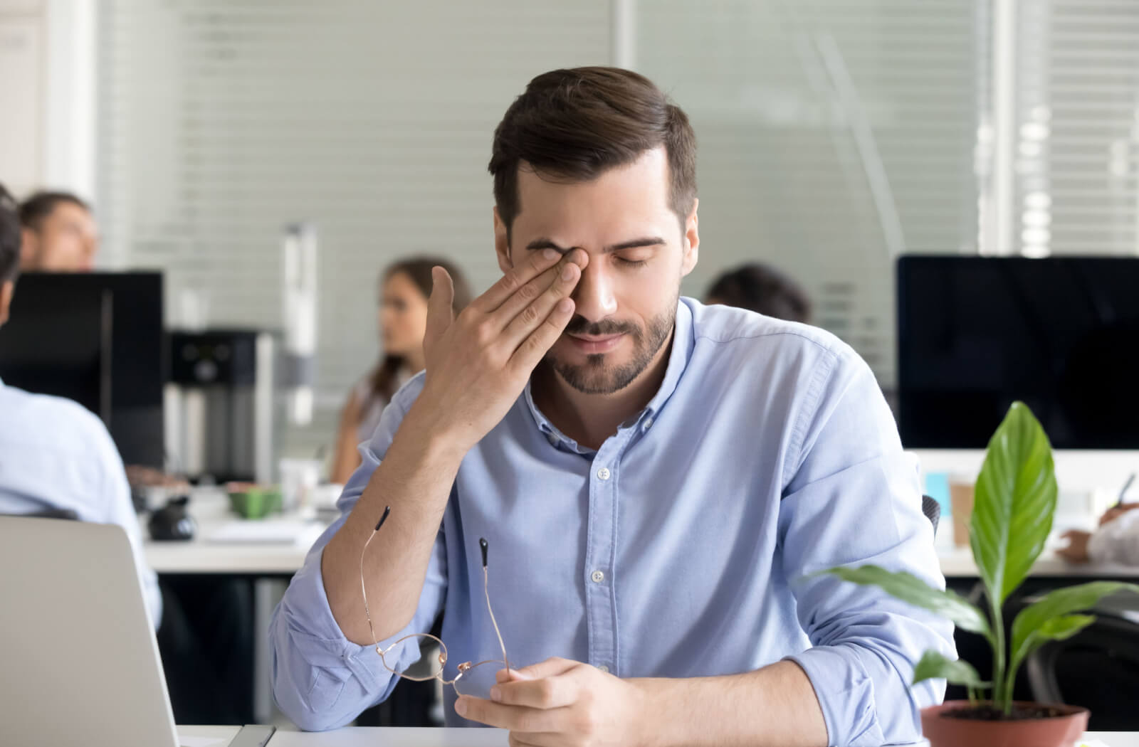 A professional-looking man rubbing his eyes.