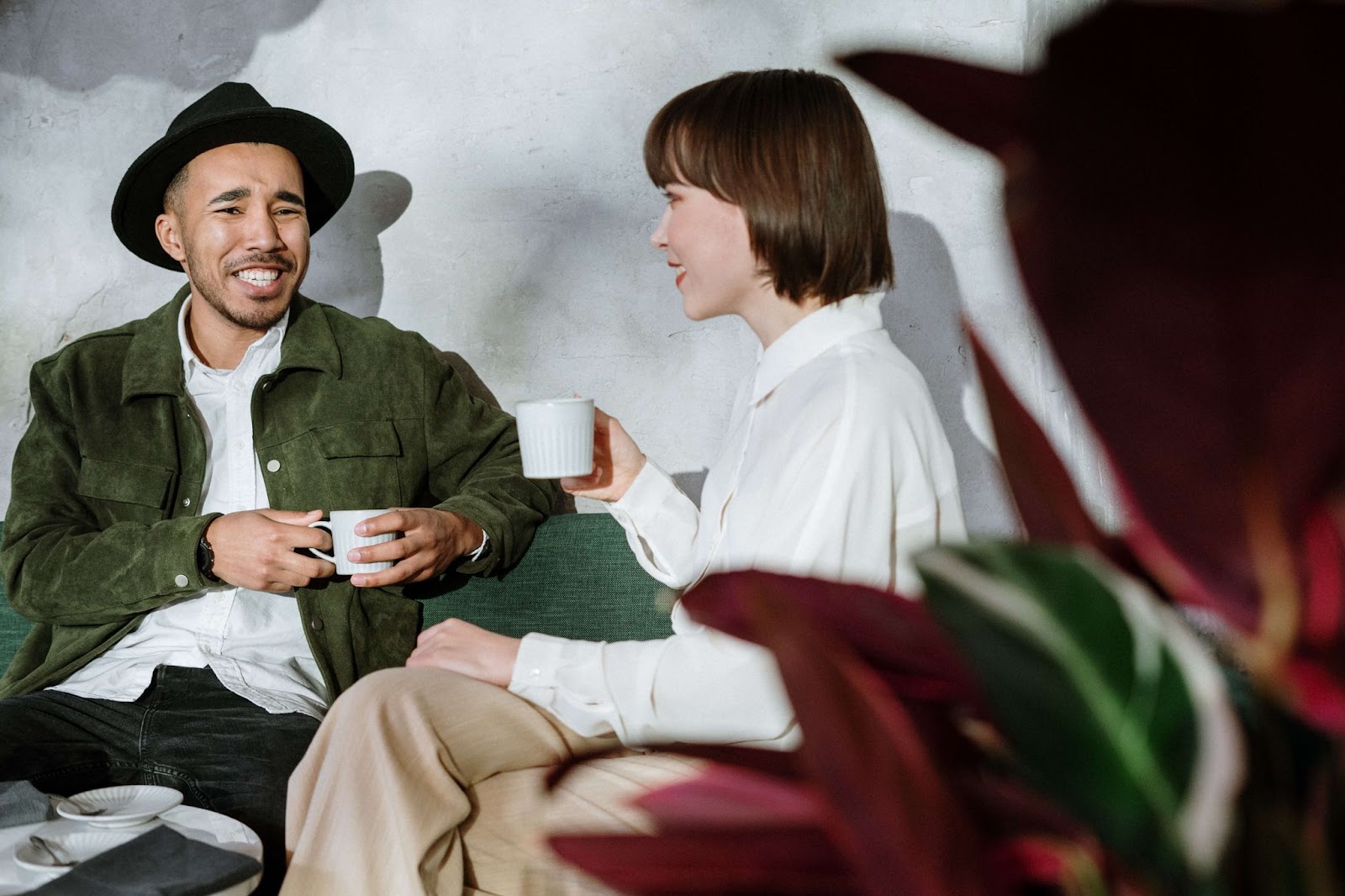 man and woman holding coffee cups and smiling