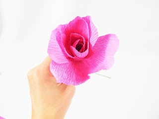 The crepe paper flower craft in Abbi's hand is now ready for the medium pre-cut petals to be added. 