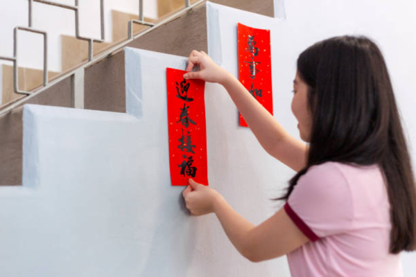 Woman putting Chinese couplets