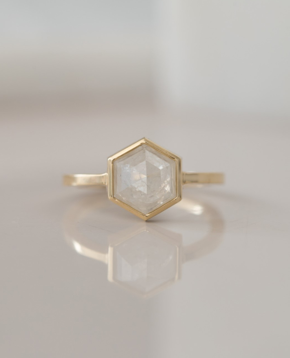 A gold ring with a diamond in it
Description automatically generated