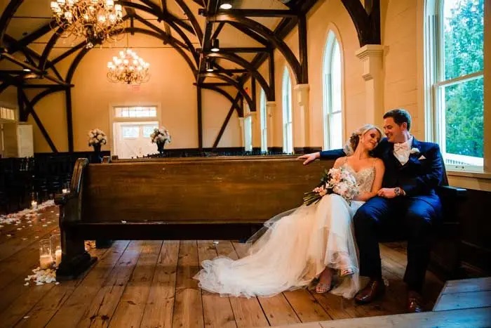 Bride and groom sitting together on a pew in the Tybee Island Wedding Chapel