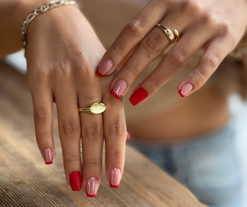 kurze Sargnägel in glänzendem Nudebraun mit roten French Tips und Akzentnägeln in Rot