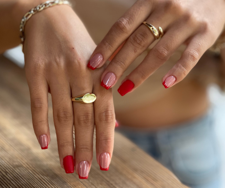 short coffin nails in glossy nude brown with red french tips and accent nails in red