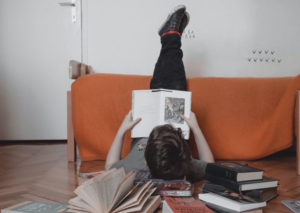 a man who's lying on the floor and reading books